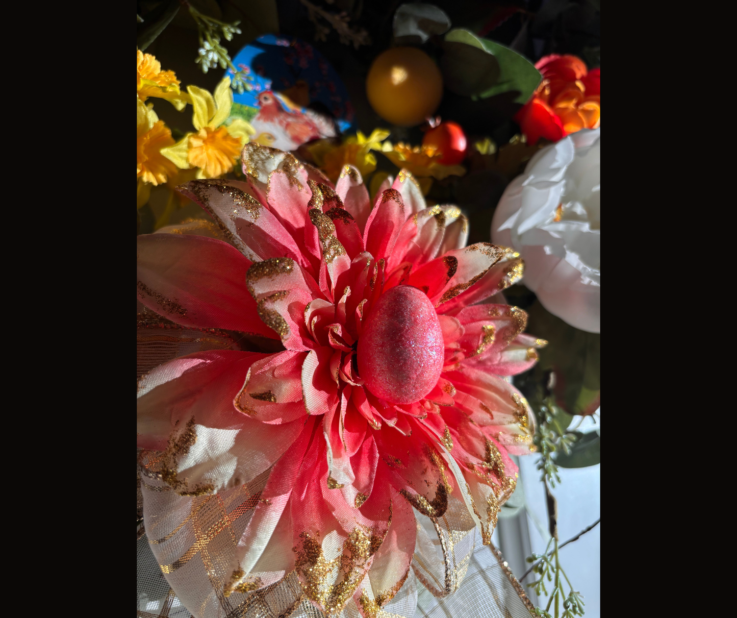 Decorative flower with pink and gold accents and magnet centerpiece with interchangeable pieces on a blurred background